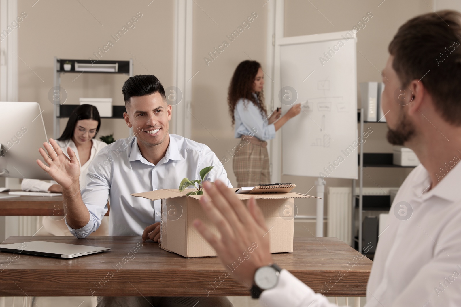 Photo of Employee greeting new coworker in modern office