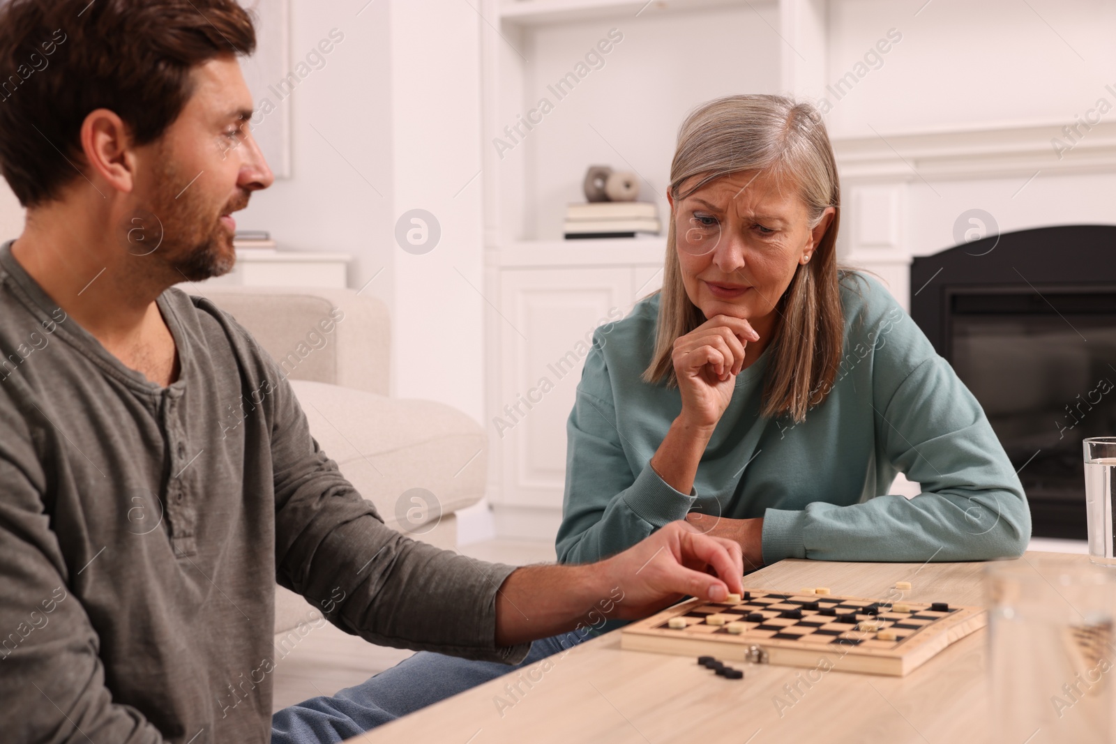 Photo of Family playing checkers at coffee table in room