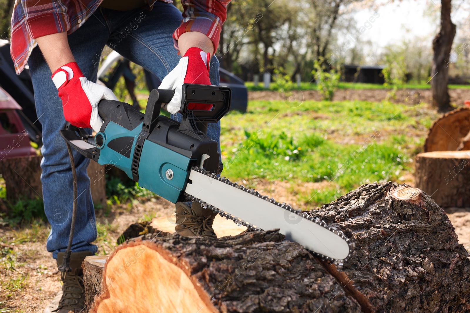 Photo of Man sawing wooden log on sunny day, closeup