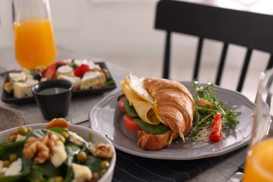 Photo of Tasty croissant sandwich with egg and cheese served on buffet table for brunch