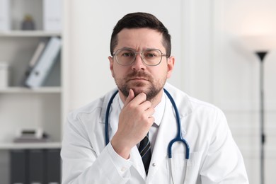 Photo of Portrait of pensive doctor with stethoscope indoors