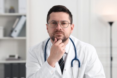 Portrait of pensive doctor with stethoscope indoors