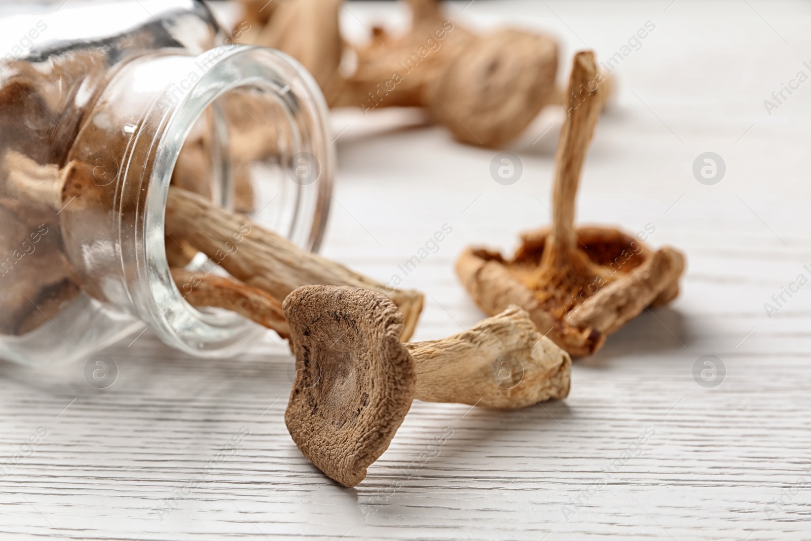 Photo of Composition of dried mushrooms and glassware on table, closeup