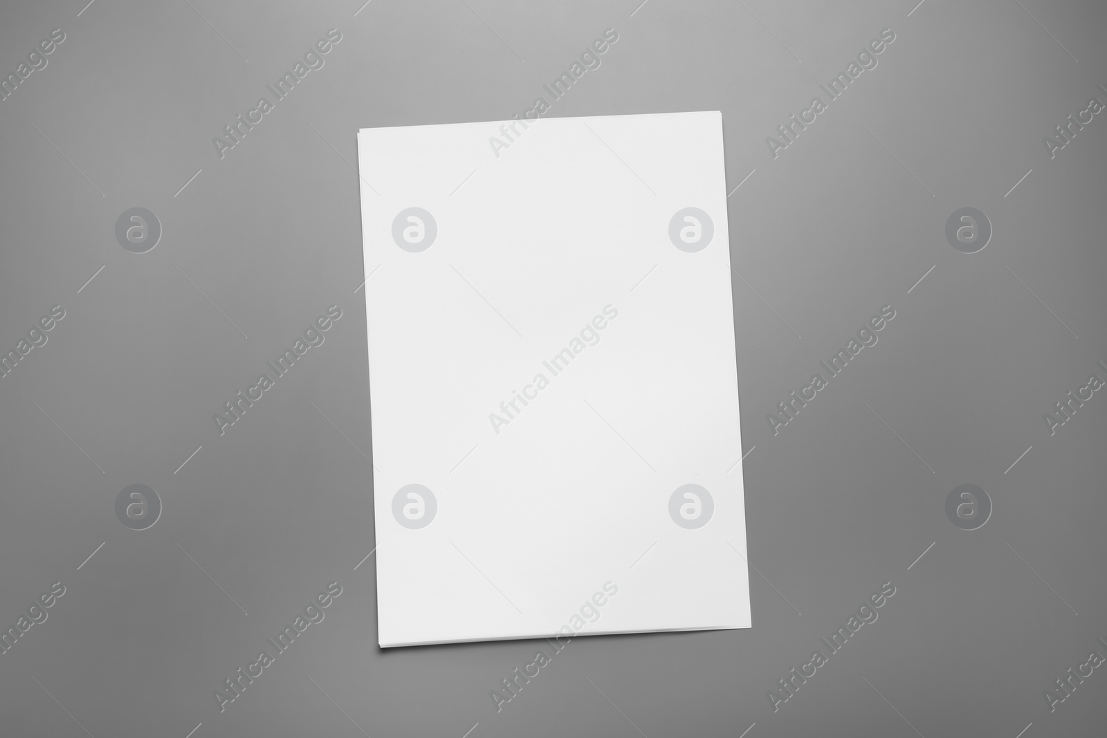 Photo of Blank paper sheets for brochure on grey background, top view. Mock up