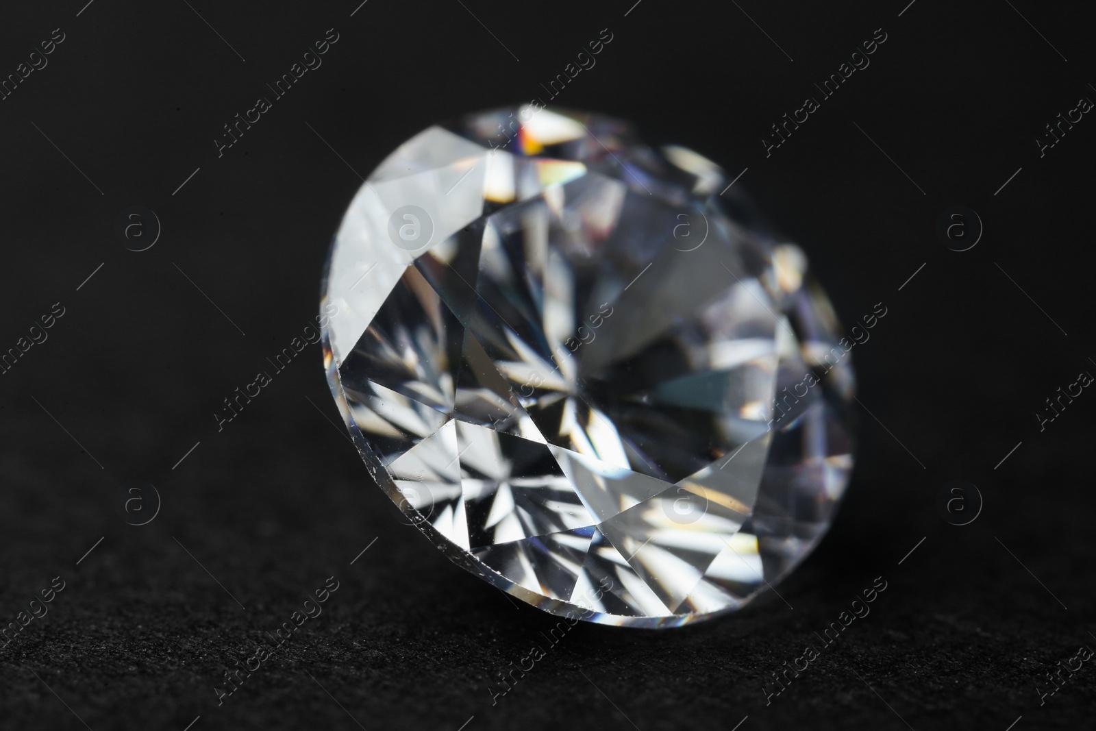 Photo of Beautiful shiny diamond on black background, closeup