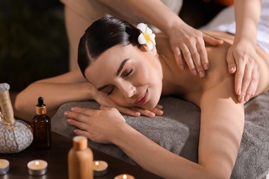 Photo of Spa therapy. Beautiful young woman lying on table during massage in salon