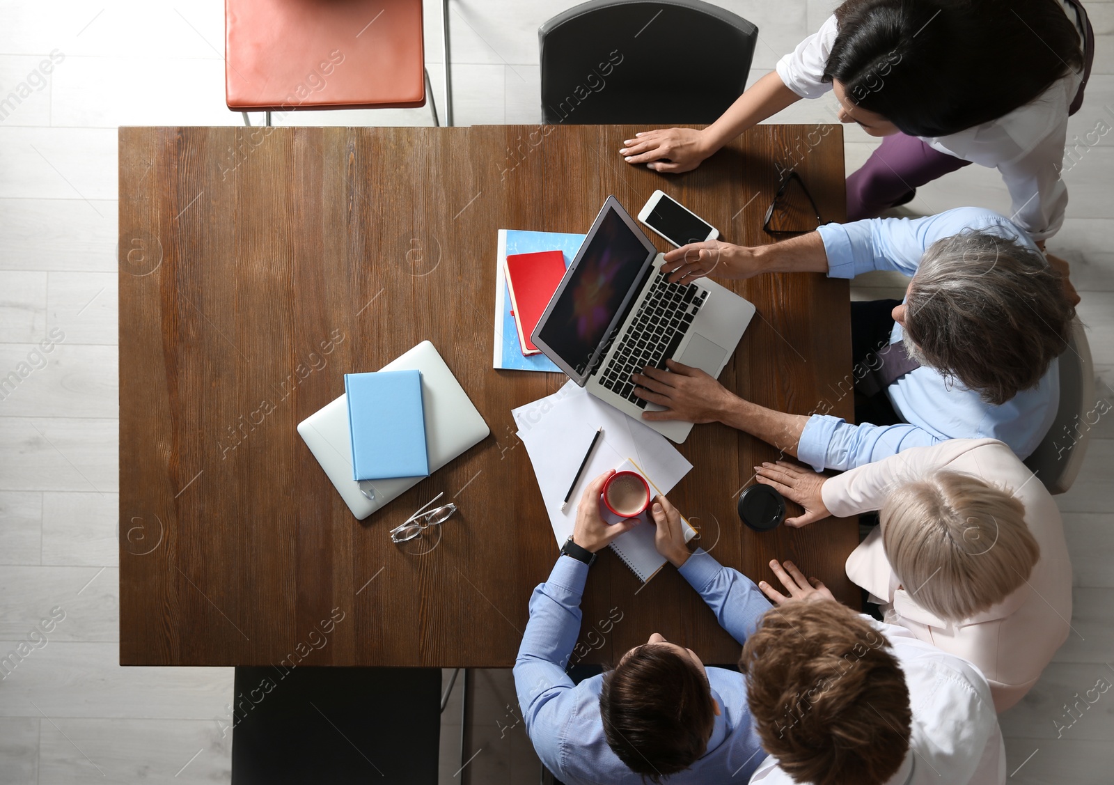 Photo of Business people discussing work matters at table in office, top view with space for text. Professional communication