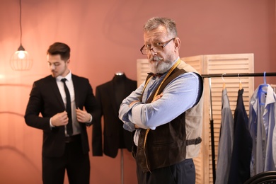 Photo of Mature tailor with client in atelier