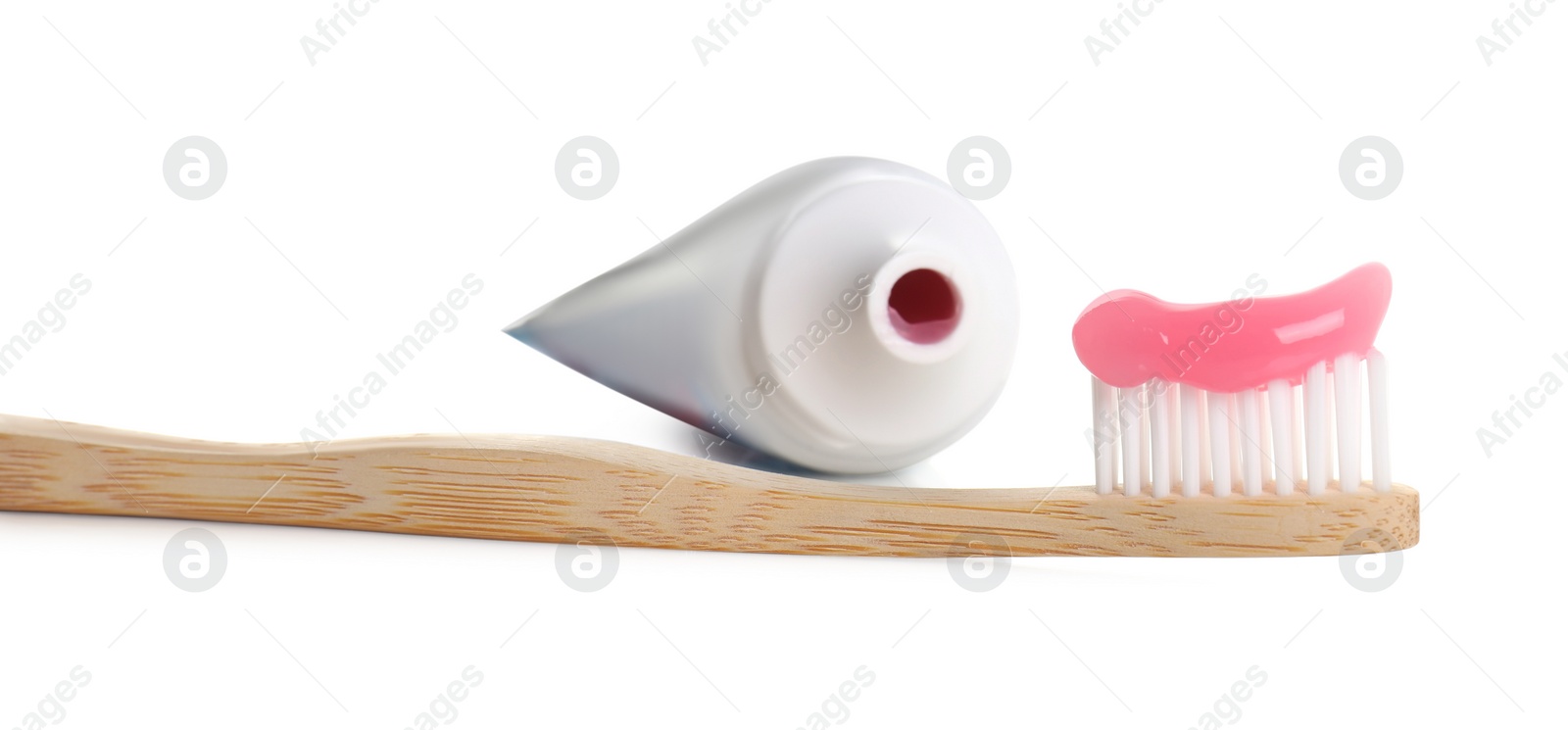 Photo of Wooden brush with toothpaste and tube on white background