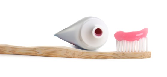 Photo of Wooden brush with toothpaste and tube on white background