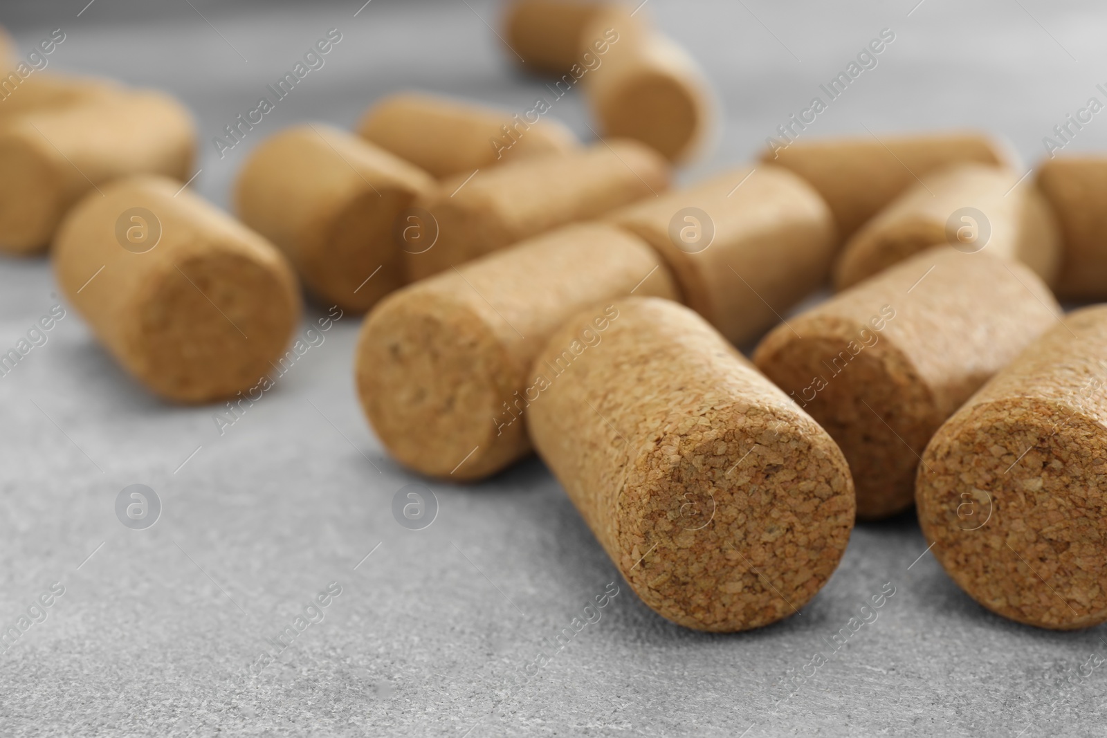 Photo of Wine bottle corks on light grey table, closeup