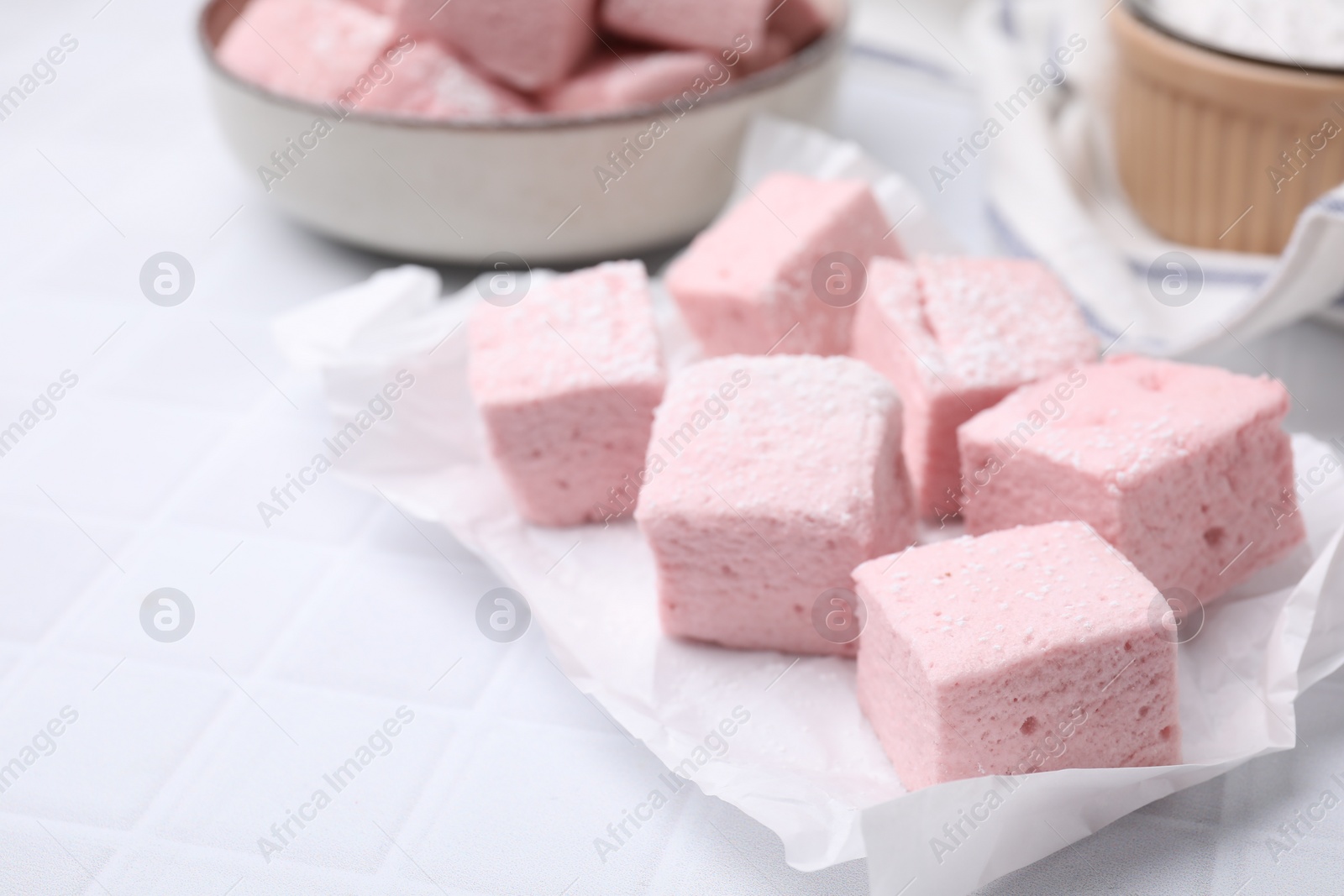 Photo of Delicious sweet marshmallows on white table, closeup. Space for text