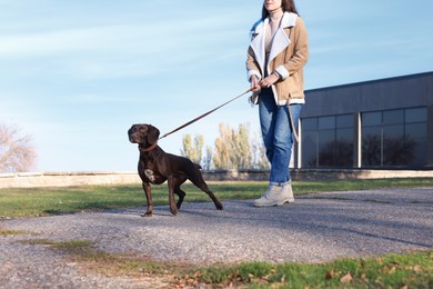 Photo of Woman with her German Shorthaired Pointer dog walking outdoors