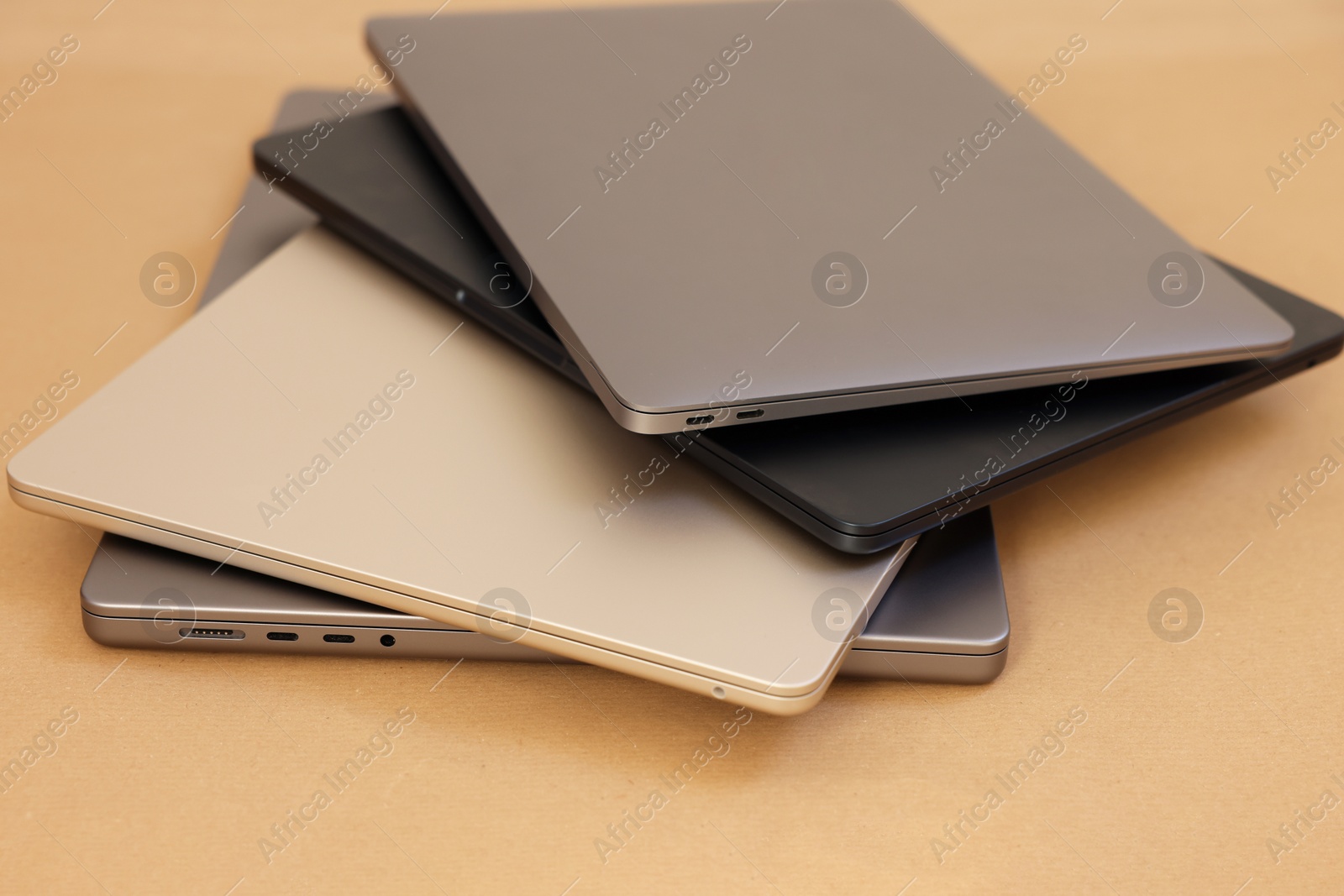 Photo of Different modern laptops on brown background, closeup