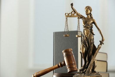 Photo of Figure of Lady Justice, gavel and books on white background, space for text. Symbol of fair treatment under law