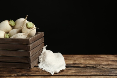 Photo of White turnips on wooden table. Space for text