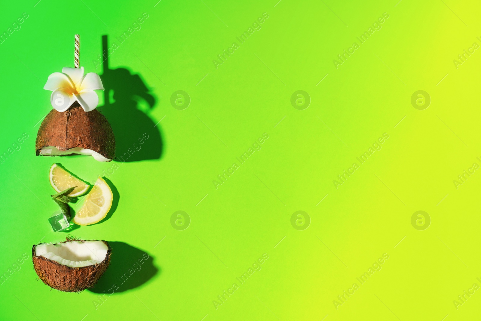 Image of Creative image of cocktail made with coconut, lemon slice, mint, ice and straw on color background, flat lay with space for text. Summer party