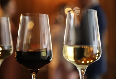 Glasses of different wines against blurred background