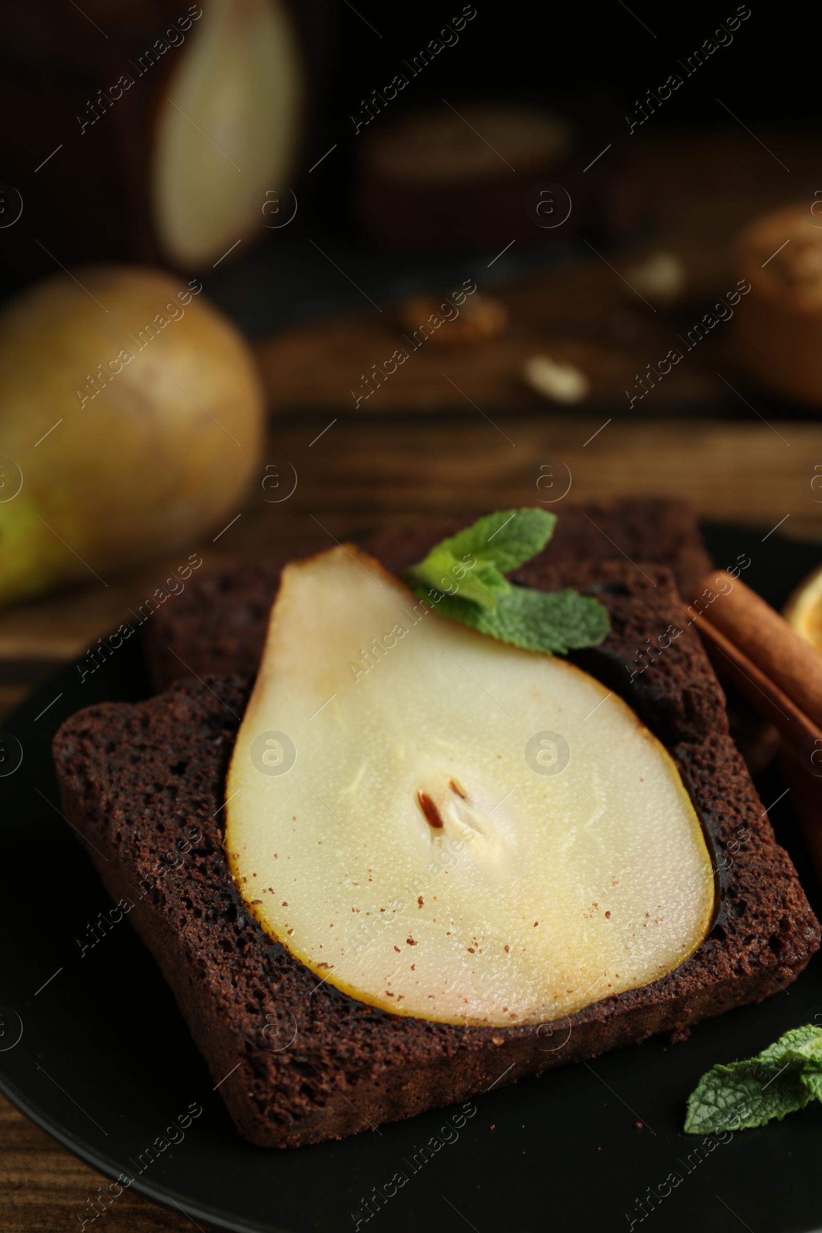 Photo of Tasty pear bread served with mint on wooden table. Homemade cake