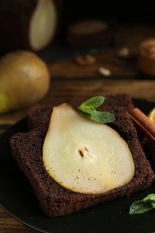 Photo of Tasty pear bread served with mint on wooden table. Homemade cake