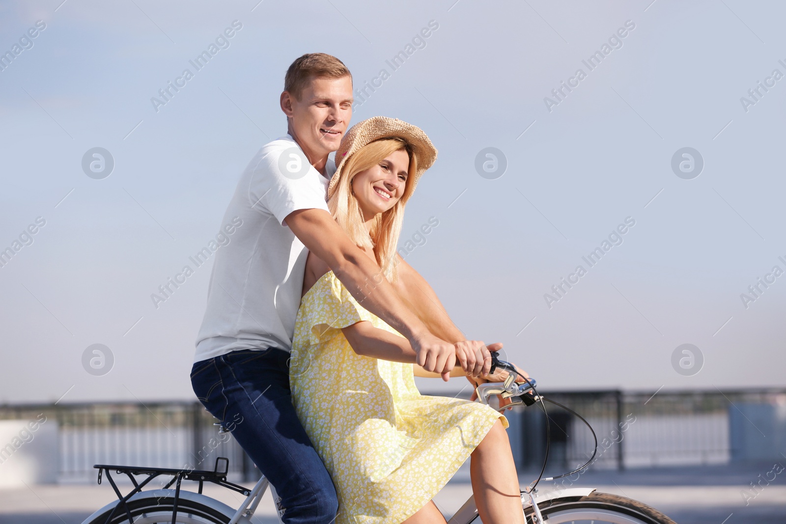 Photo of Happy couple riding bicycle outdoors on sunny day