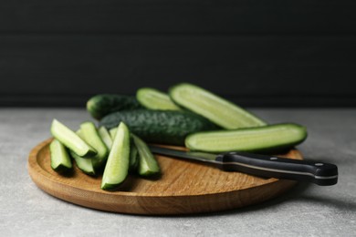 Photo of Whole and cut fresh ripe cucumbers on grey table