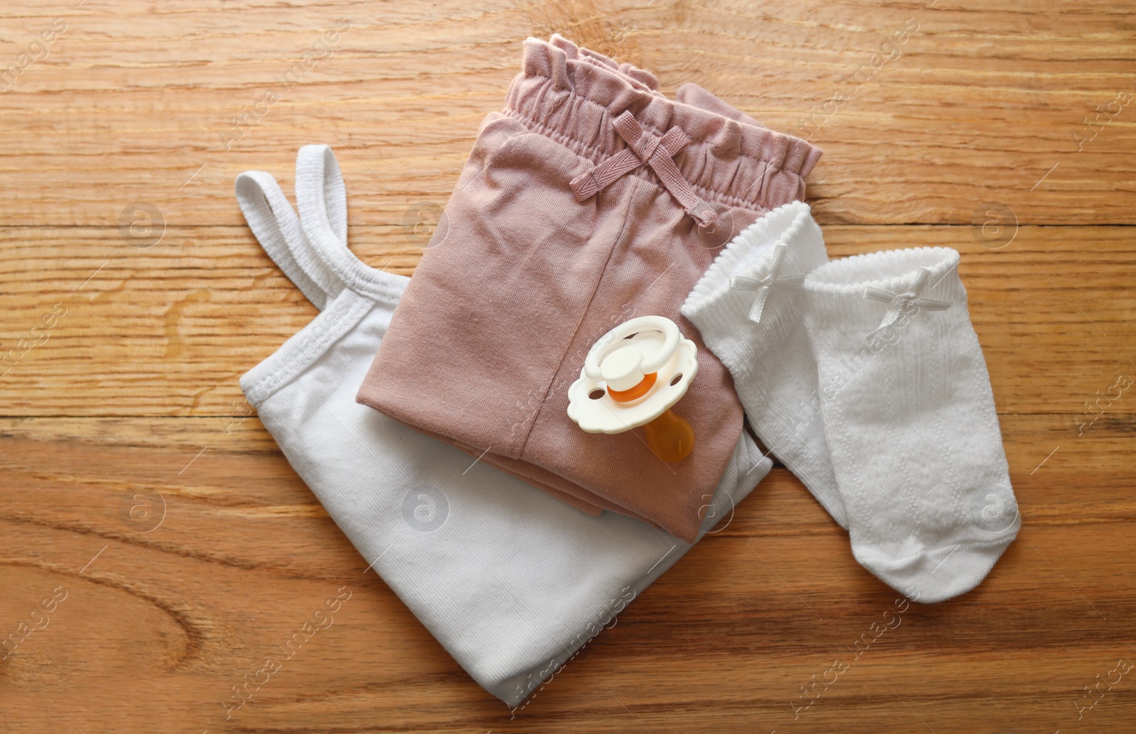 Photo of Stylish child clothes and accessories on wooden background, flat lay