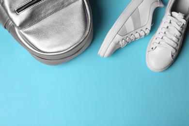 Photo of Flat lay composition of stylish shoes and backpack on color background, space for text