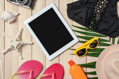 Photo of Flat lay composition with beach objects and tablet on wooden background