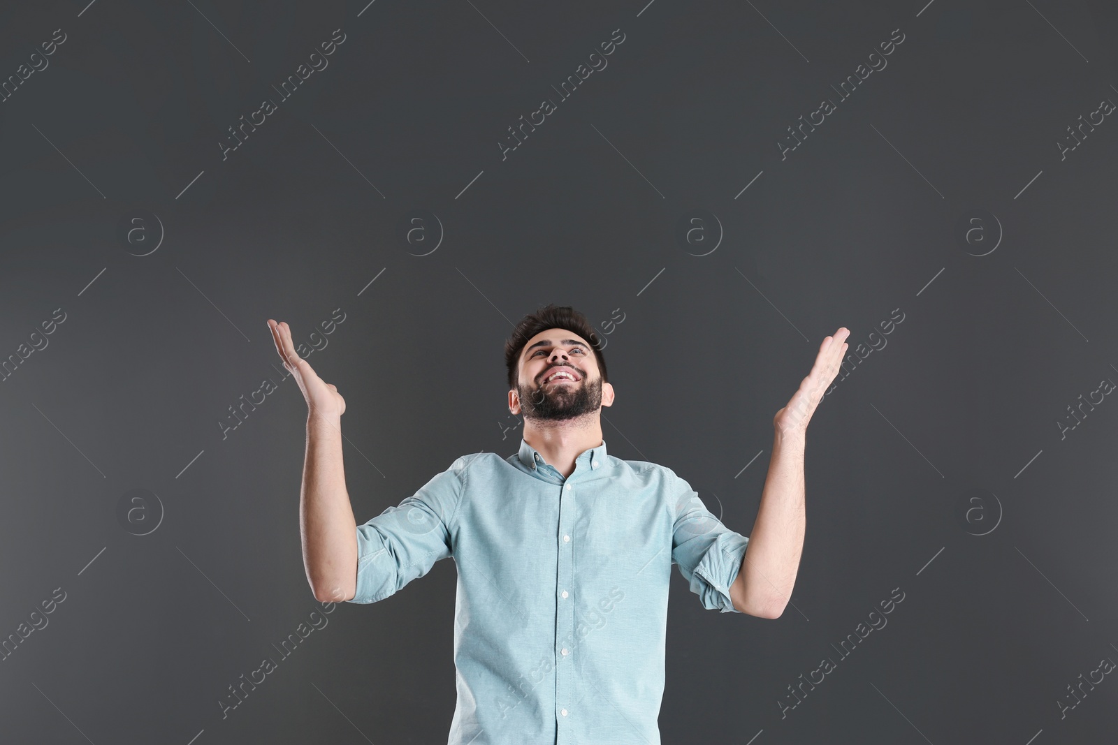 Photo of Portrait of happy young man on grey background. Space for text