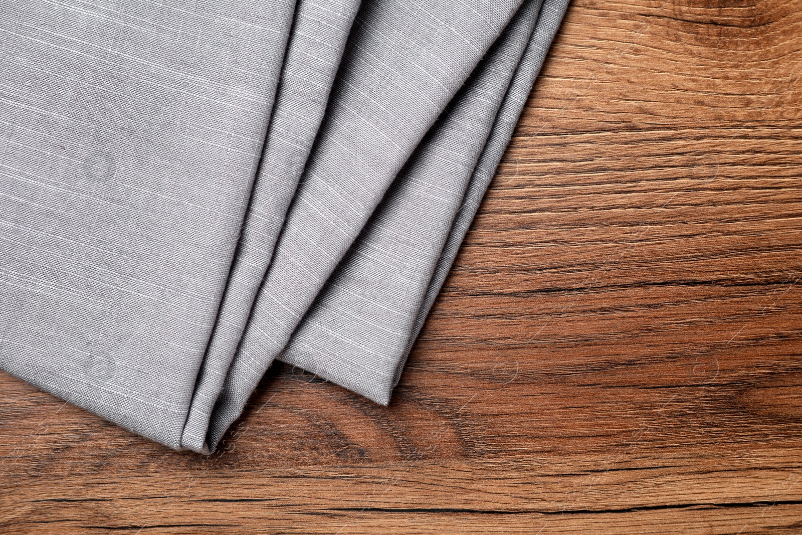 Photo of Grey hemp cloth on wooden table, top view. Space for text