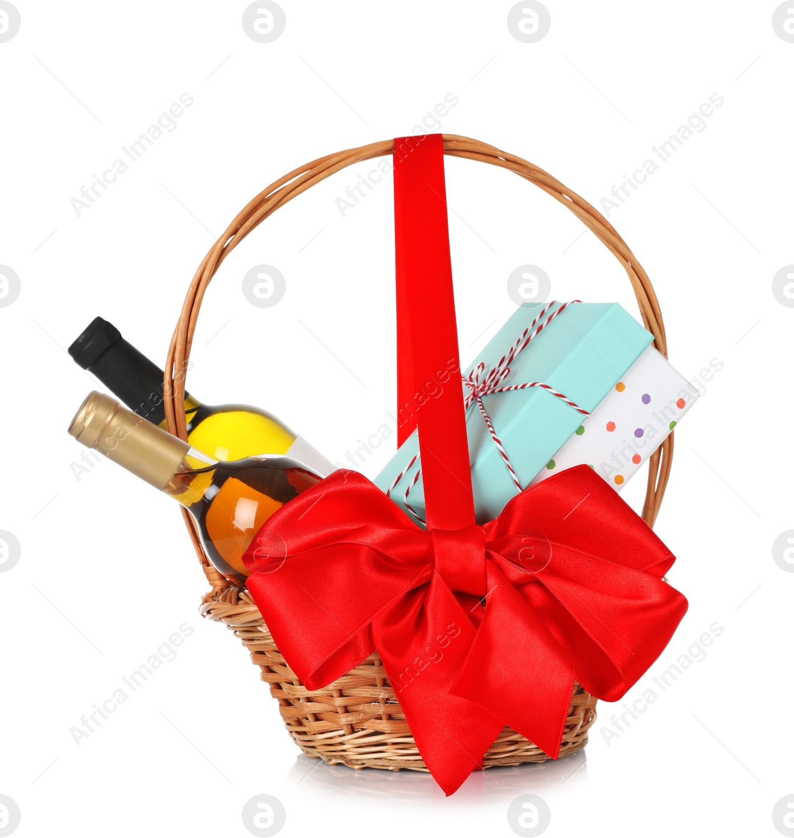 Photo of Bottles of wine and gift box in wicker basket with red bow isolated on white