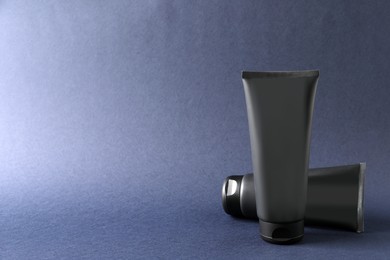 Photo of Tubes of men's facial cream on grey background. Space for text