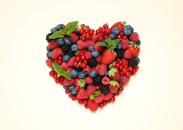 Mix of different fresh berries and mint on light background, flat lay