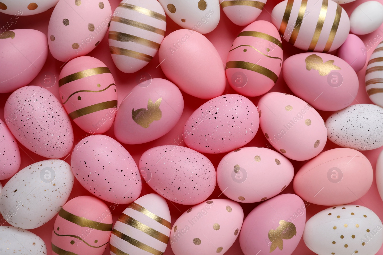 Photo of Many painted Easter eggs on pink background, flat lay