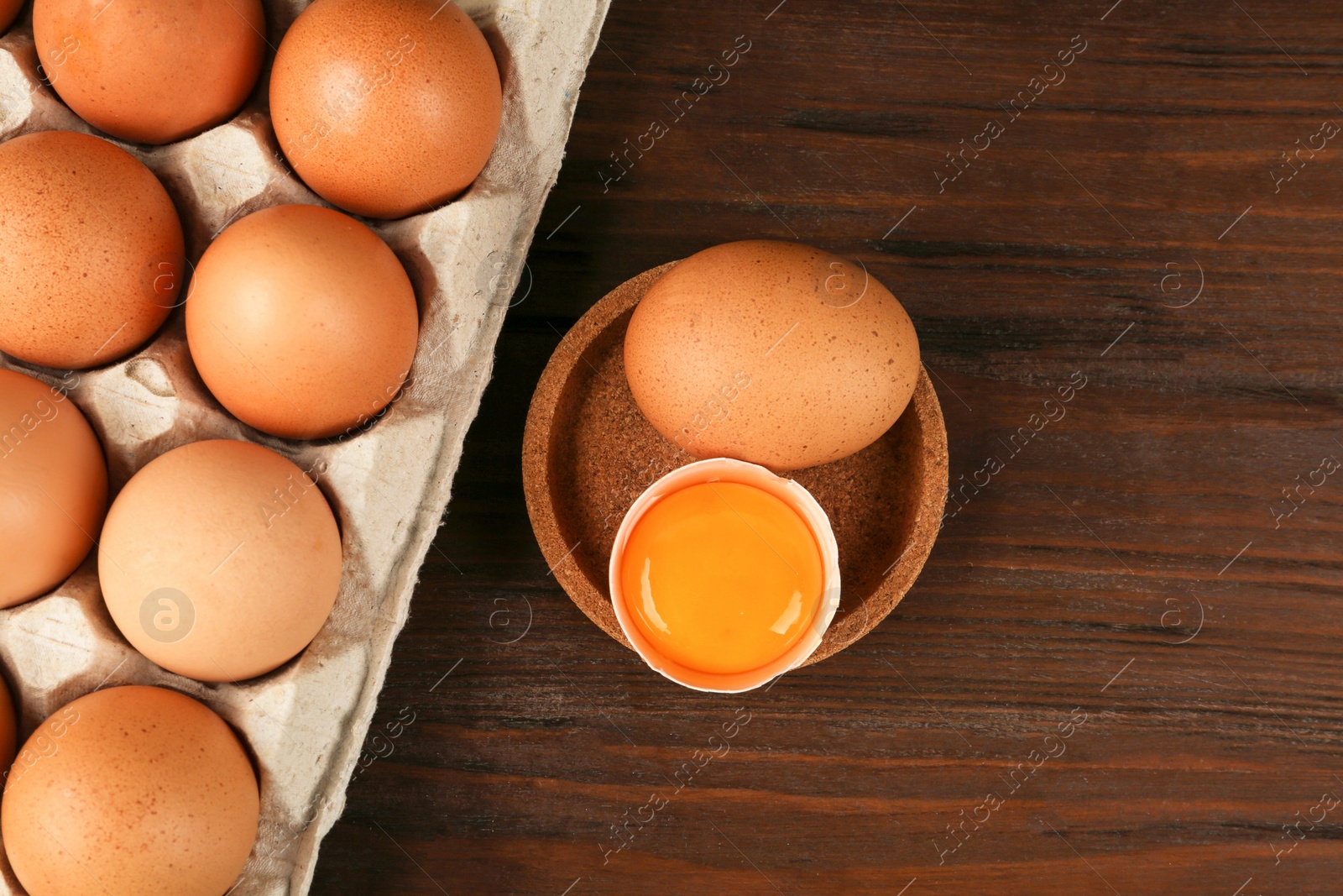 Photo of Raw chicken eggs on wooden table, flat lay