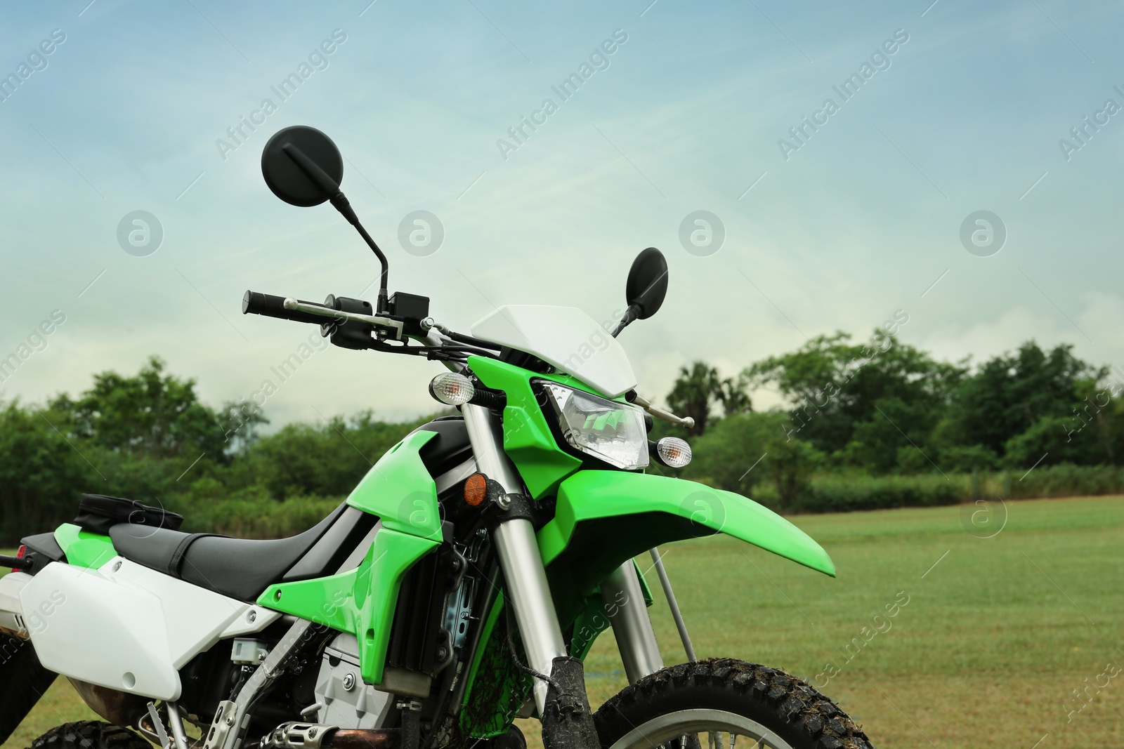 Photo of Stylish green cross motorcycle on grass outdoors