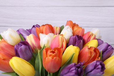 Photo of Bouquet of beautiful colorful tulips on white wooden background, closeup