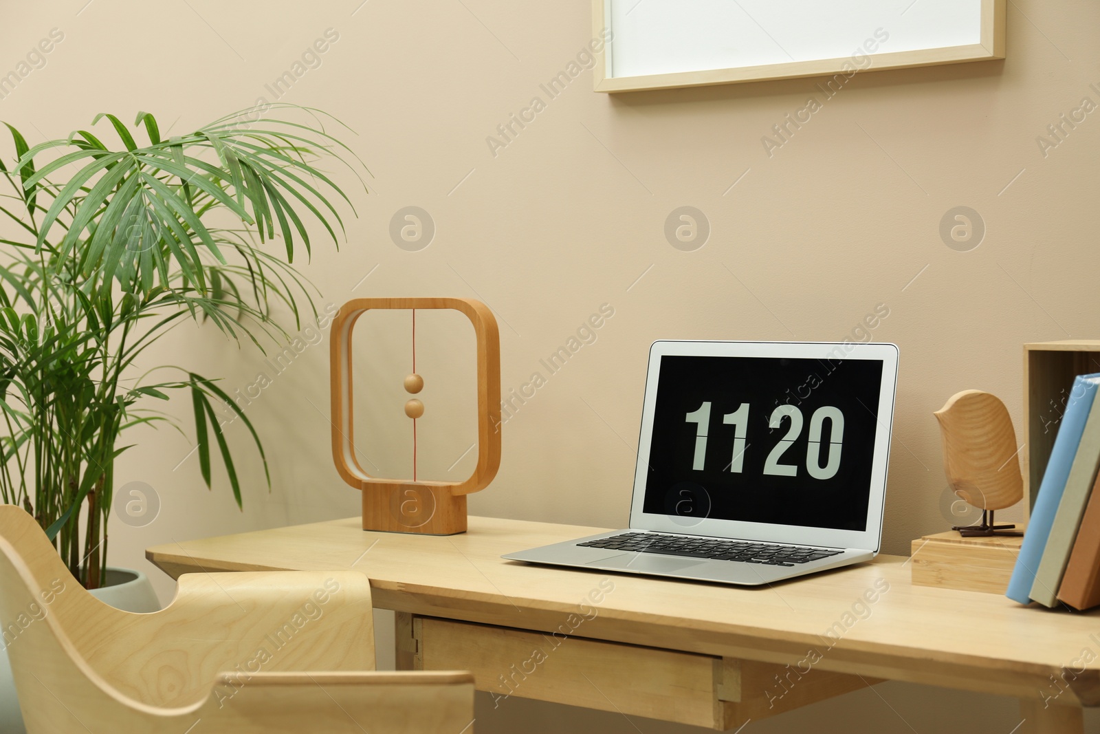 Photo of Stylish workplace with laptop, notebooks and houseplant indoors. Interior design