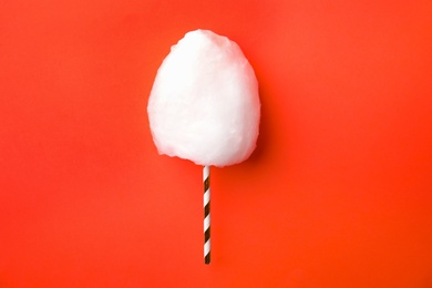 Photo of Straw with yummy cotton candy on color background, top view