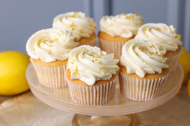 Delicious lemon cupcakes with white cream on table, closeup