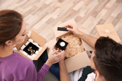 Young couple opening parcels at home, closeup