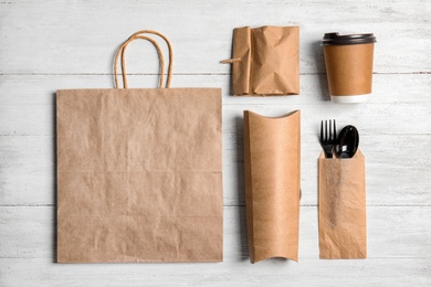 Photo of Different containers for mock up design on wooden background, flat lay. Food delivery service