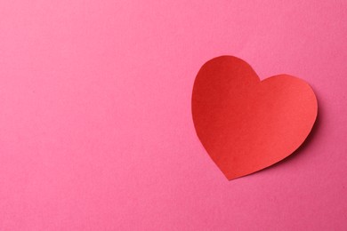 Photo of Red paper heart on pink background, top view. Space for text