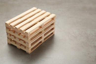 Stack of wooden pallets on light grey table, space for text