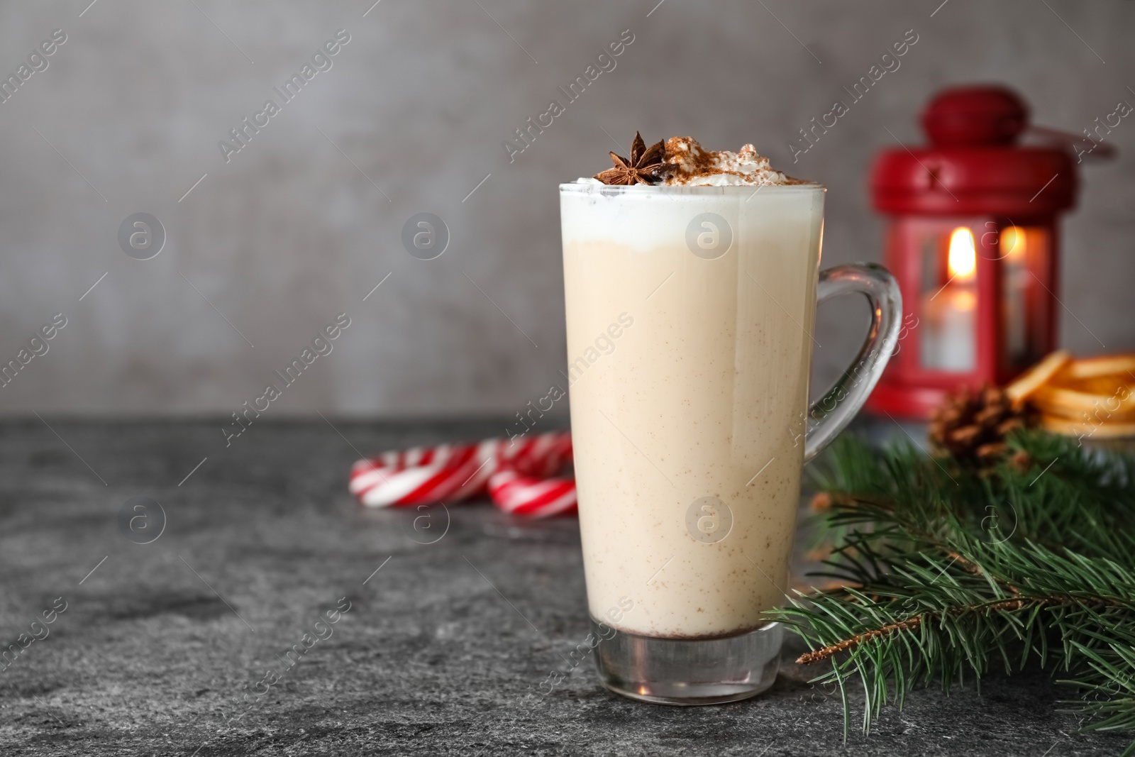 Photo of Delicious Christmas cocktail with liqueur on grey table. Space for text