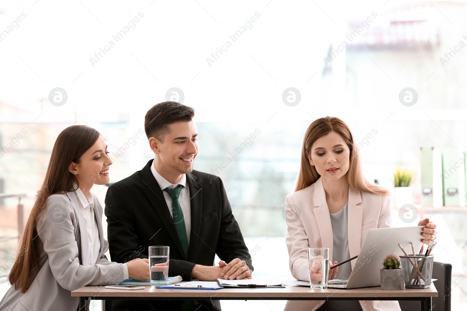 Photo of Young consultant working with clients in office