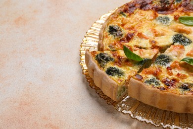 Photo of Delicious homemade quiche with salmon and broccoli on beige table, closeup. Space for text