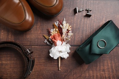Photo of Wedding stuff. Flat lay composition with stylish boutonniere on wooden background