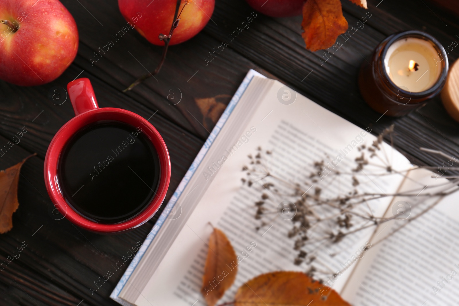 Photo of Cup of hot drink, book and ripe apples on wooden table, flat lay. Cozy autumn atmosphere
